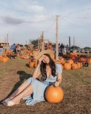 girl sitting with pumpkin at halls pumpkin farm